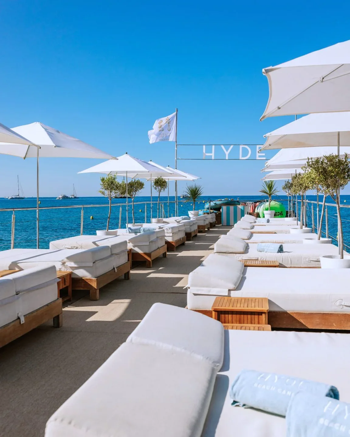 Hyde Beach Cannes offers luxurious sun loungers and white umbrellas overlooking the Mediterranean Sea.