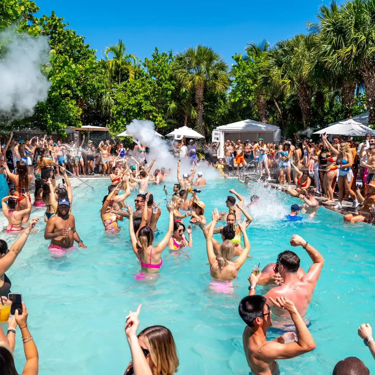 Pool party at Hyde Beach in Miami with people enjoying the water and music