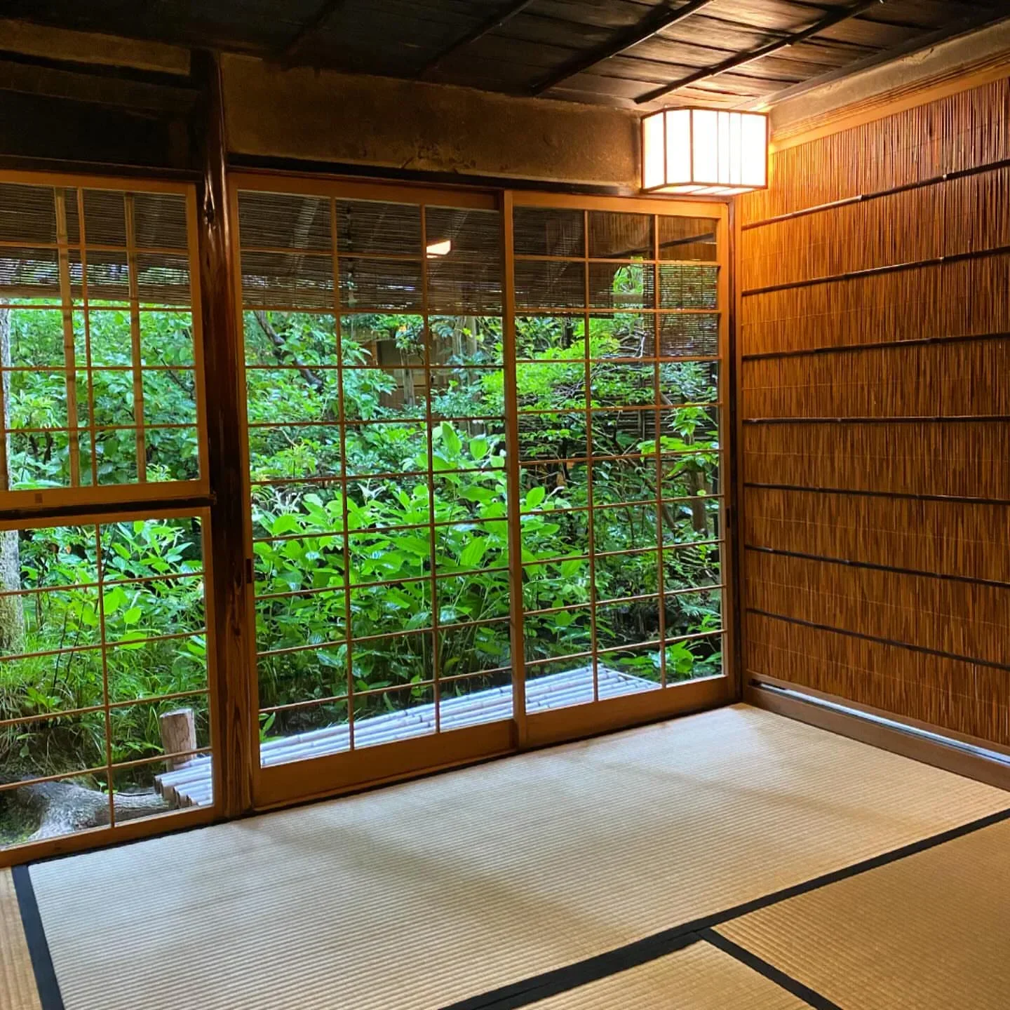 Interior of Hyotei restaurant in Kyoto, with garden views through wooden-framed windows.