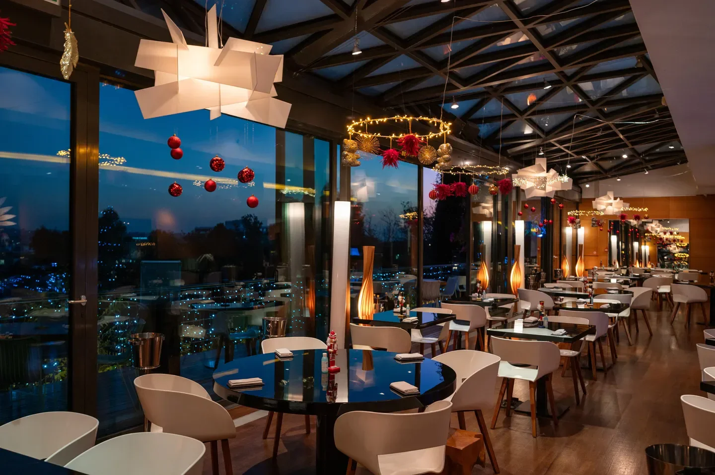 Elegant interior of Hytra restaurant in Athens, Greece, with city views and festive decor.