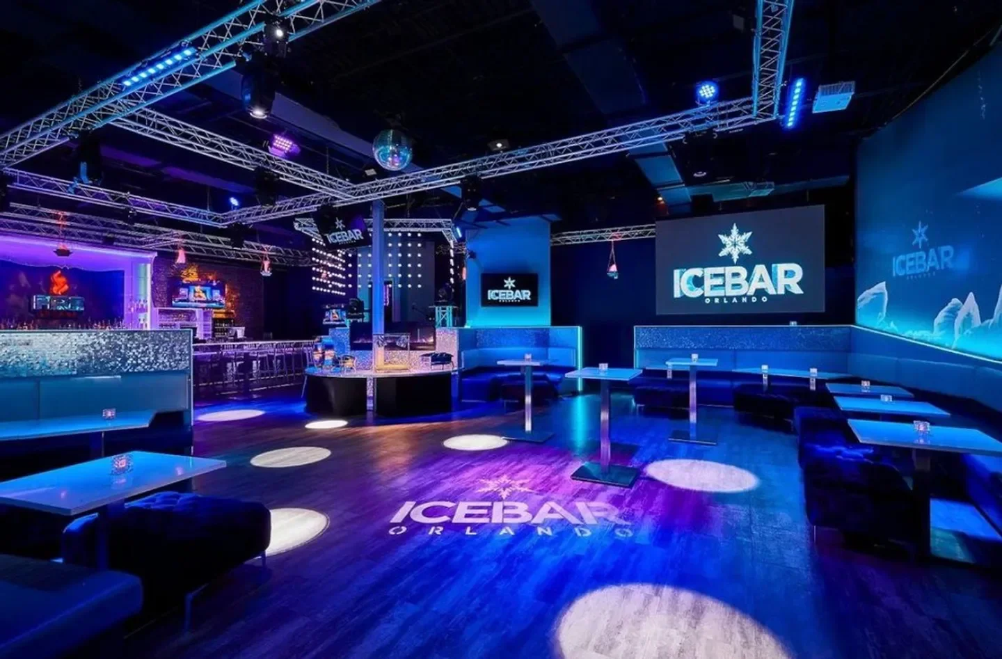 Inside ICEBAR Orlando: a vibrant nightclub with blue lighting and a lively atmosphere.