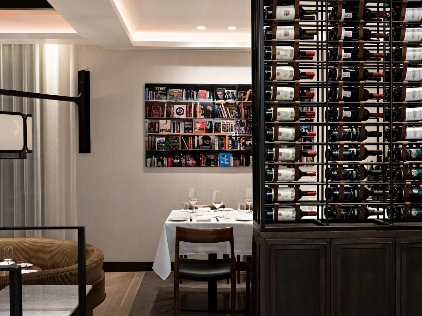 Elegant dining at Il Caminetto in Whistler, showcasing wine rack and stylish decor.