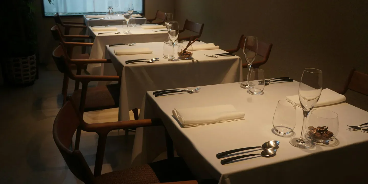 Elegant dining tables set for service inside Il Centrino restaurant in Osaka.