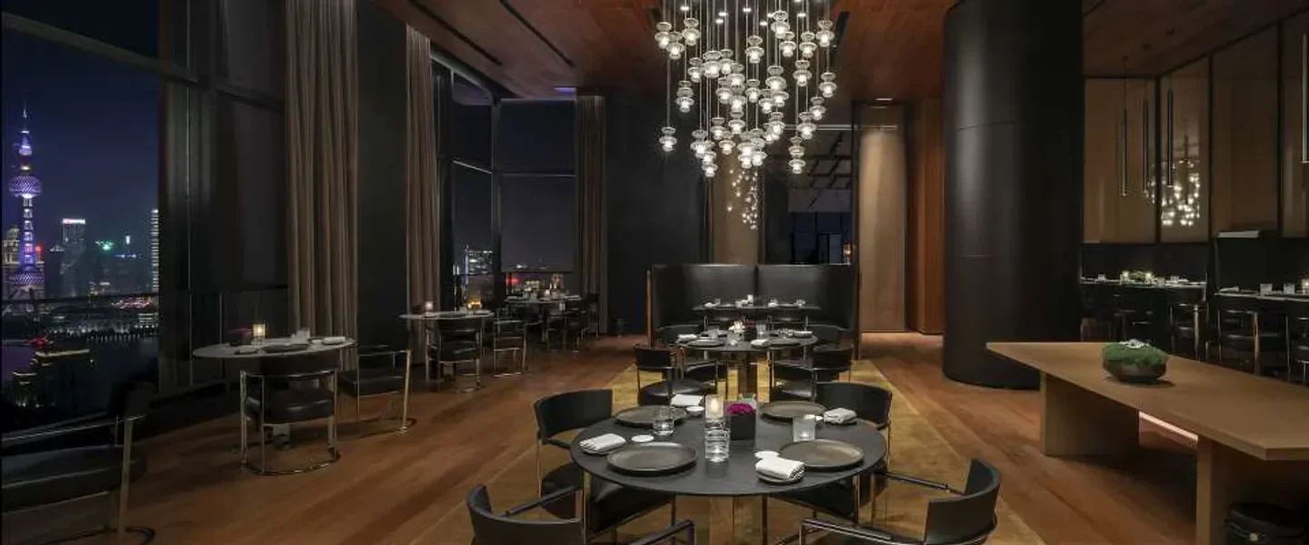 Elegant interior of Il Ristorante Niko Romito - Shanghai, with city views of Shanghai at night.