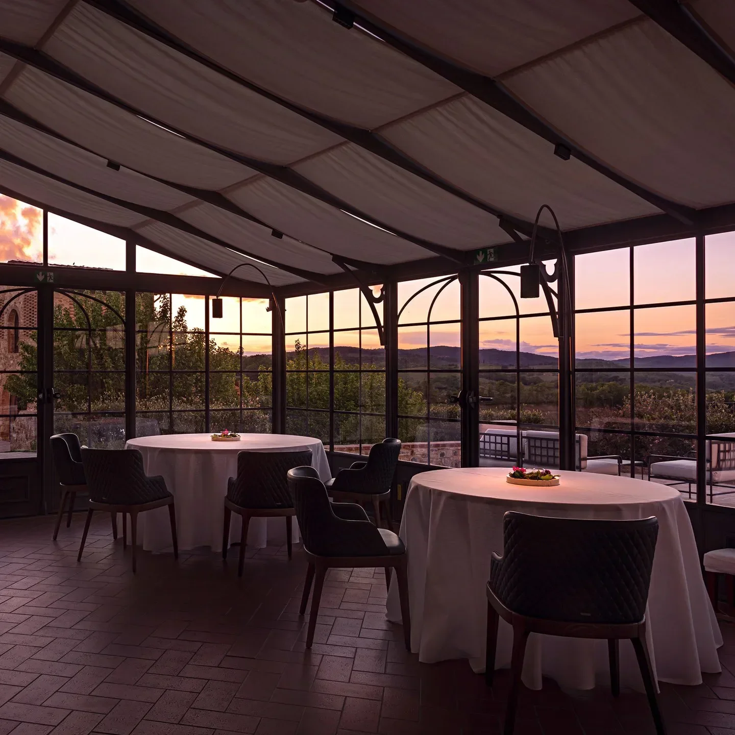 Dining room at Il Visibilio restaurant in Tuscany with sunset views over the hills