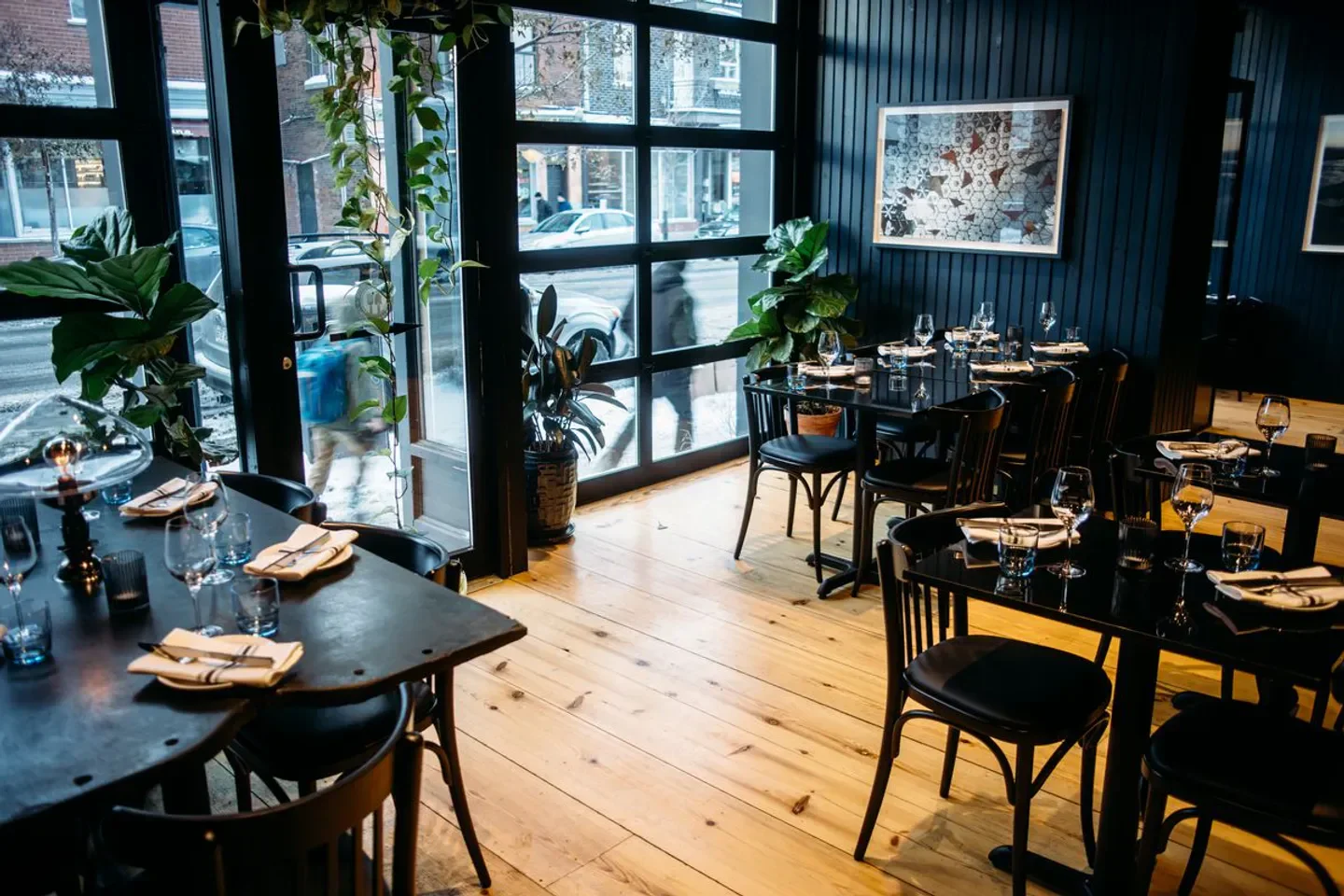 Interior dining space at Île Flottante restaurant in Montreal, featuring wooden floors and tables.