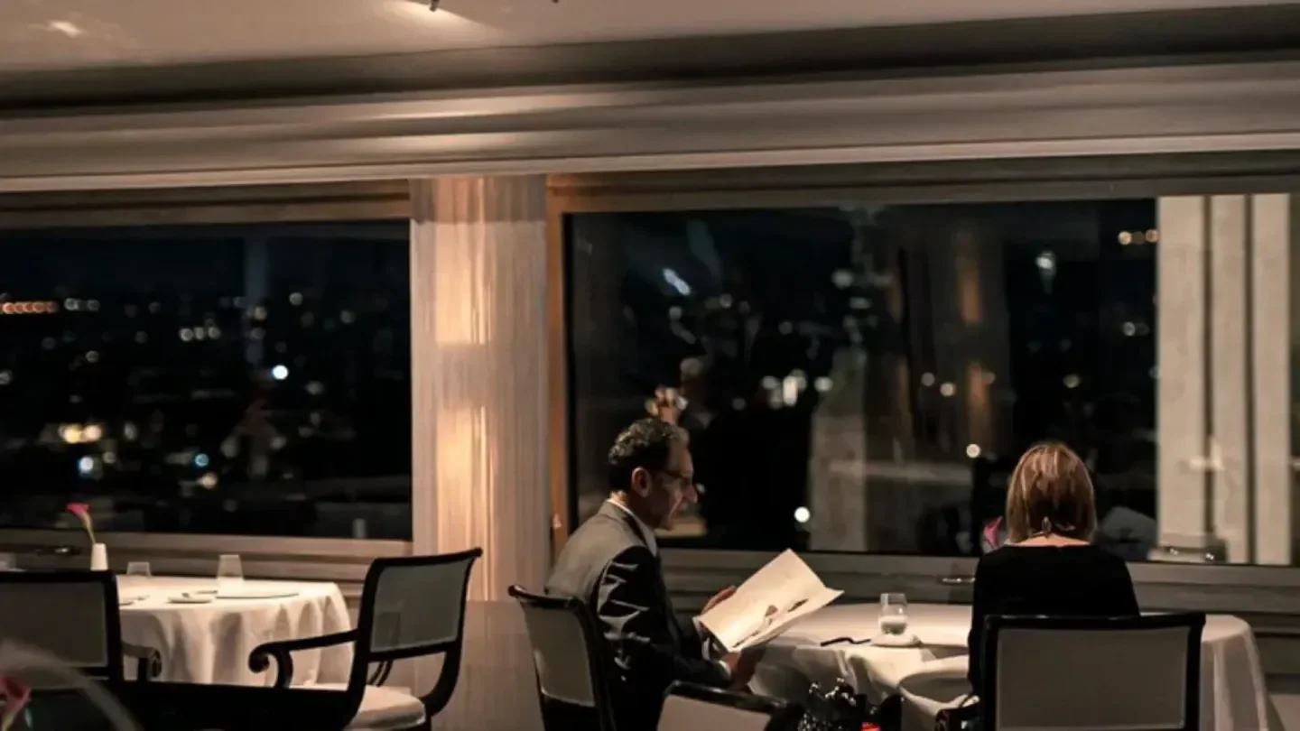 Dining at Imàgo in Rome with city views at night, elegant restaurant setting.
