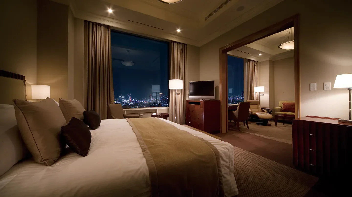 Cozy bedroom at Imperial Hotel, Osaka, with city views overlooking Osaka at night.