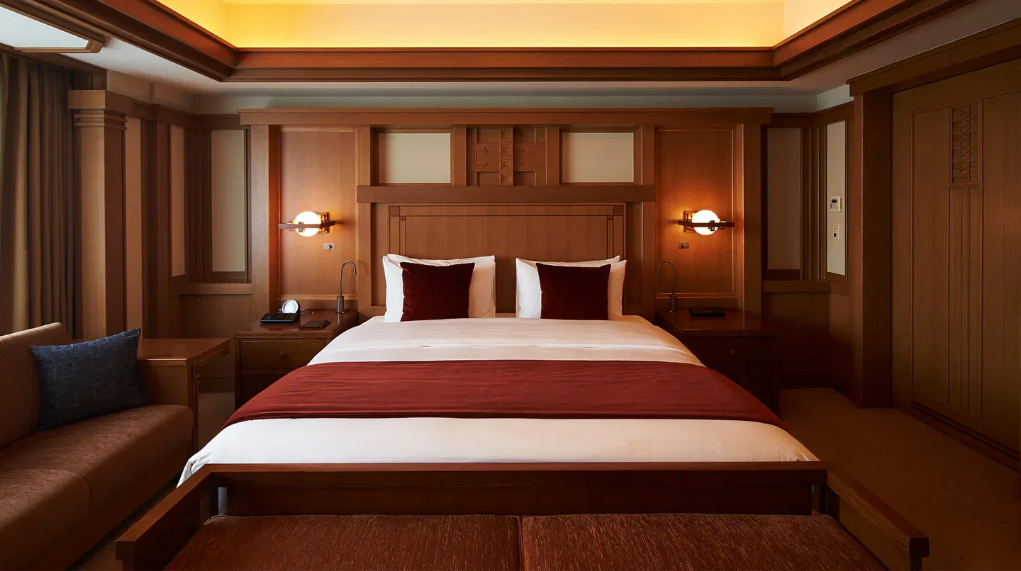 Cozy bedroom at the Imperial Hotel, Tokyo, featuring wood paneling and a comfortable bed in Tokyo.
