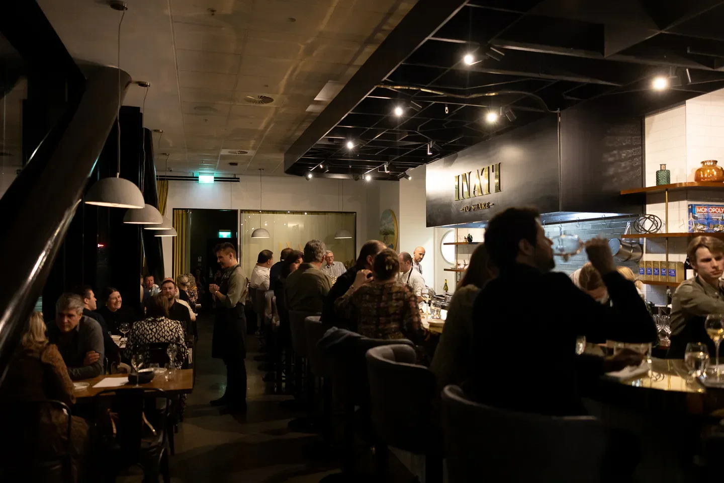 Inside Inati restaurant in Christchurch, showcasing bar seating and dining area with patrons.