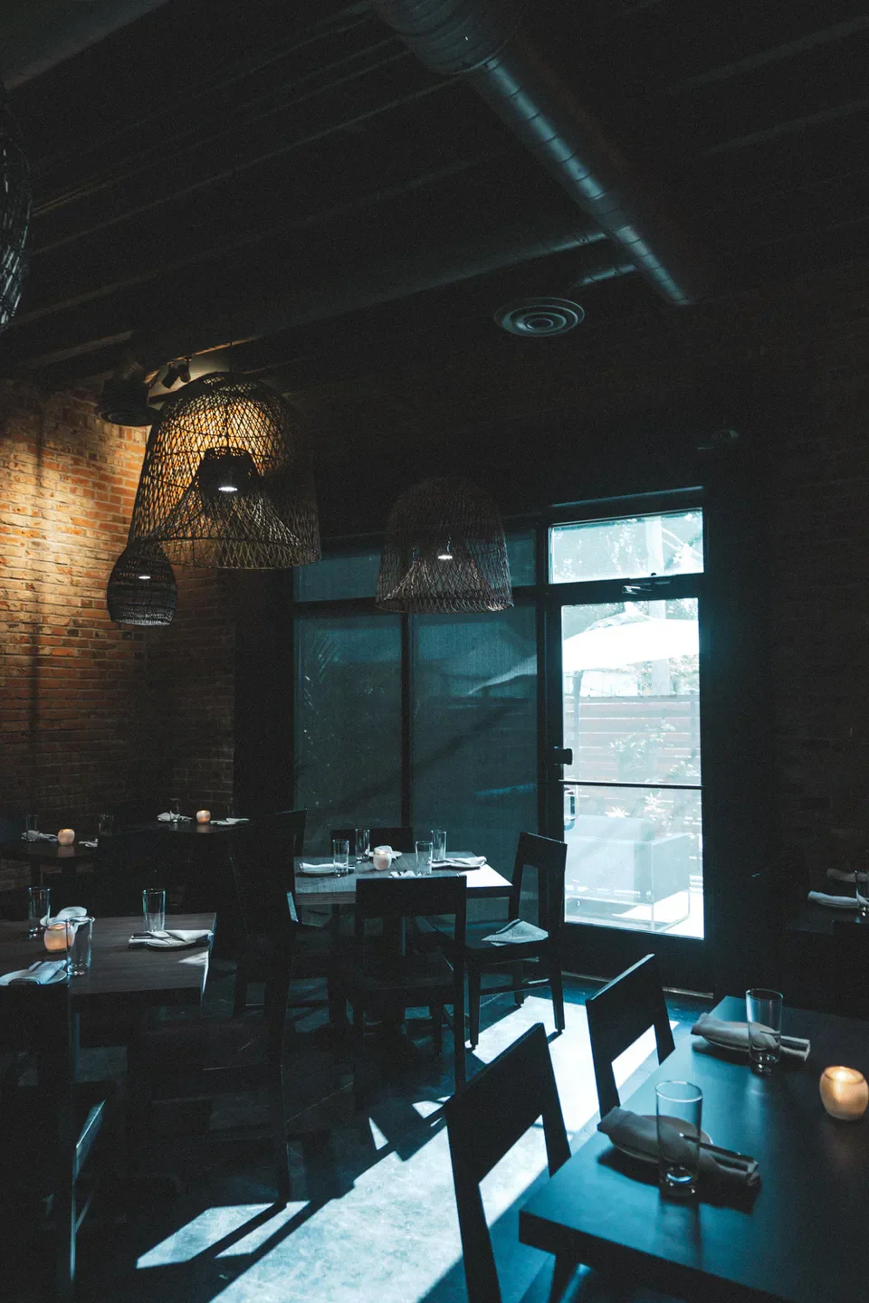 Interior of iNDO restaurant in St. Louis, showcasing tables, chairs, and stylish lighting.