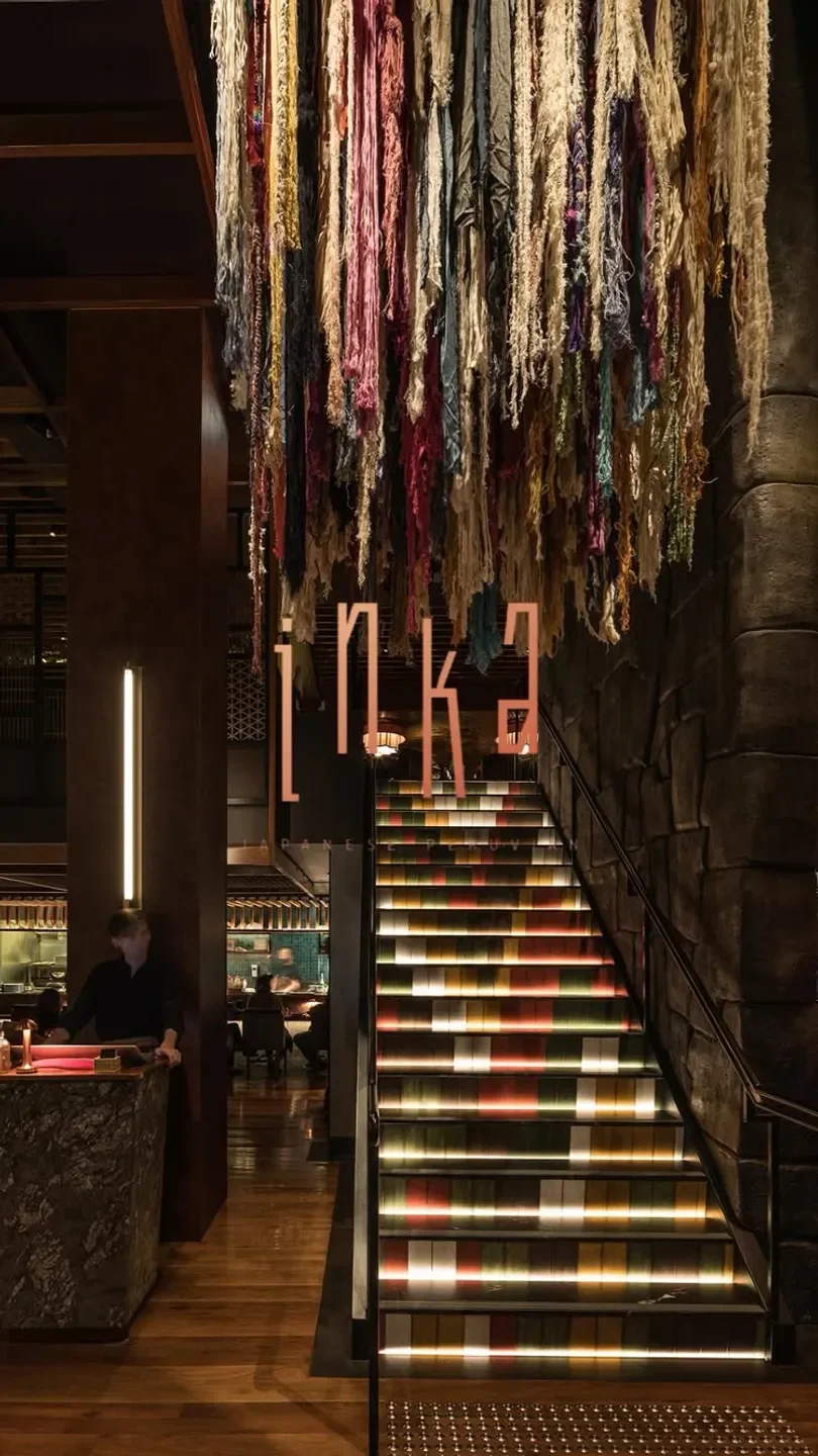 Colorful staircase and Inka sign in Canberra restaurant, with striking textured decor.