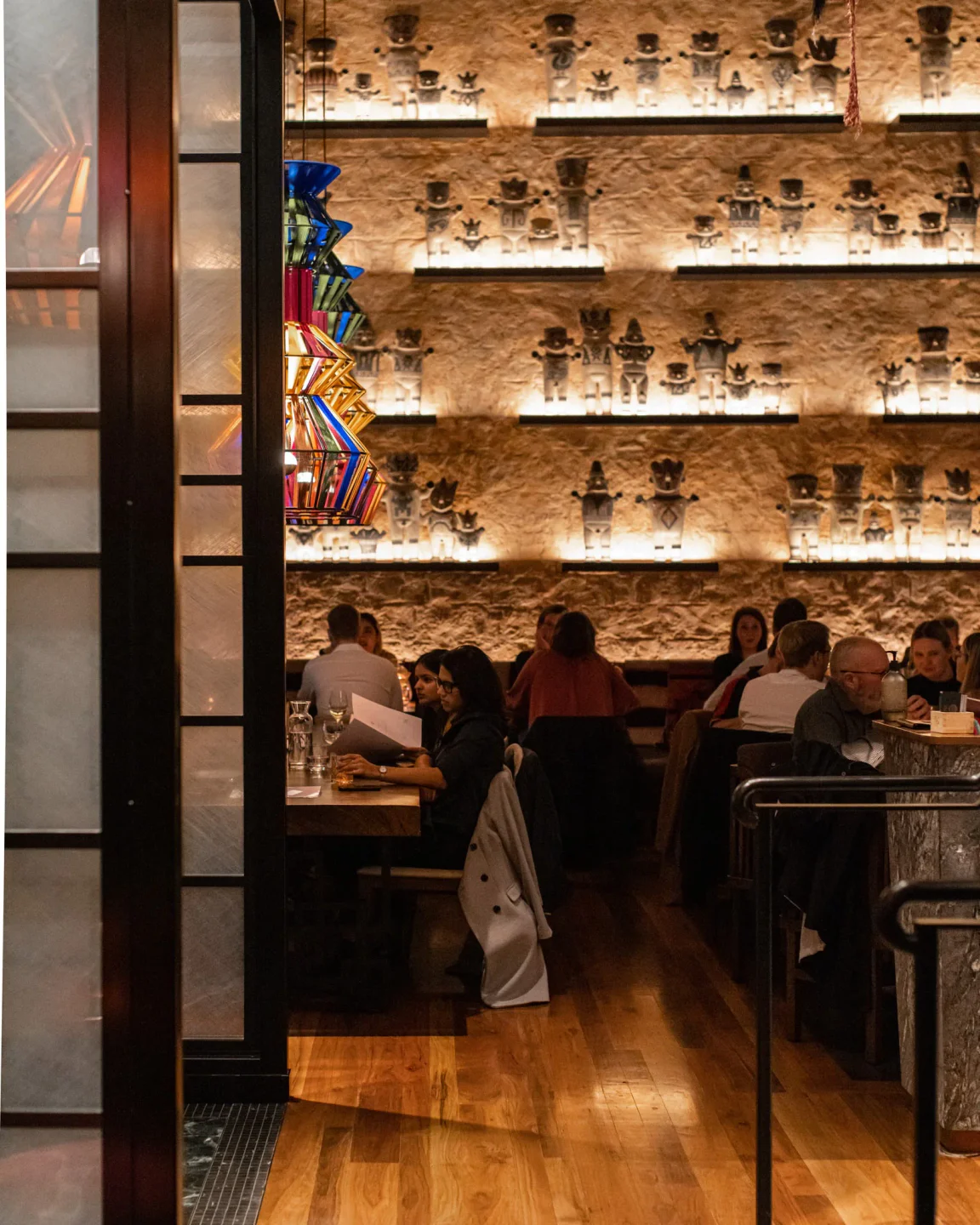 Interior of INKA restaurant in Canberra, Australia, featuring stylish decor and ambient lighting with patrons dining.