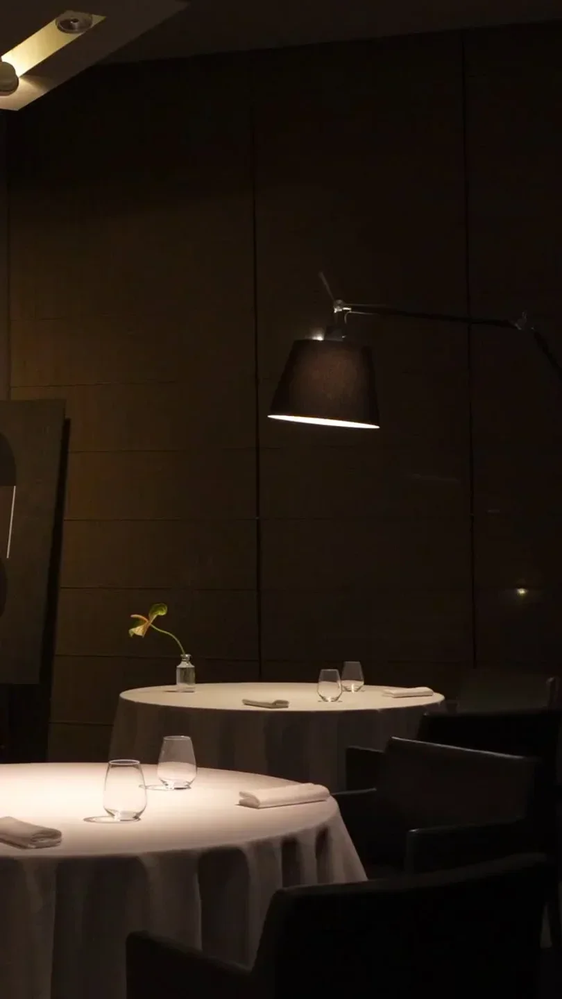 Elegant dining room interior at Inkiostro in Parma, with a moody, dark ambiance