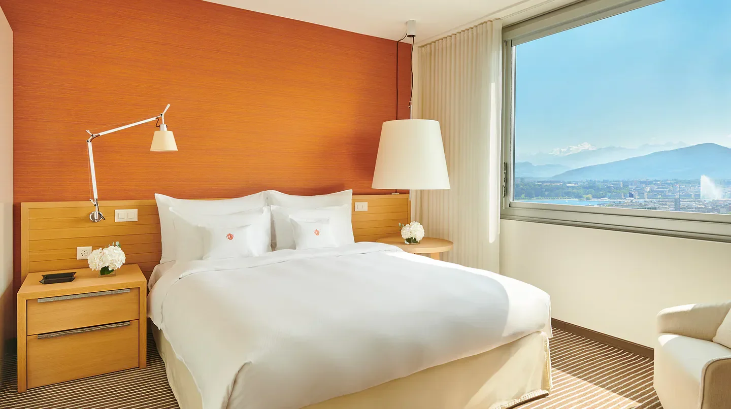 Cozy bedroom at the InterContinental Geneva hotel with a stunning view of Geneva, Switzerland.