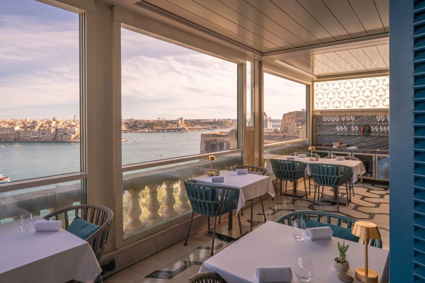 Elegant dining room at ION Harbour by Simon Rogan in Malta with sea views and modern seating.