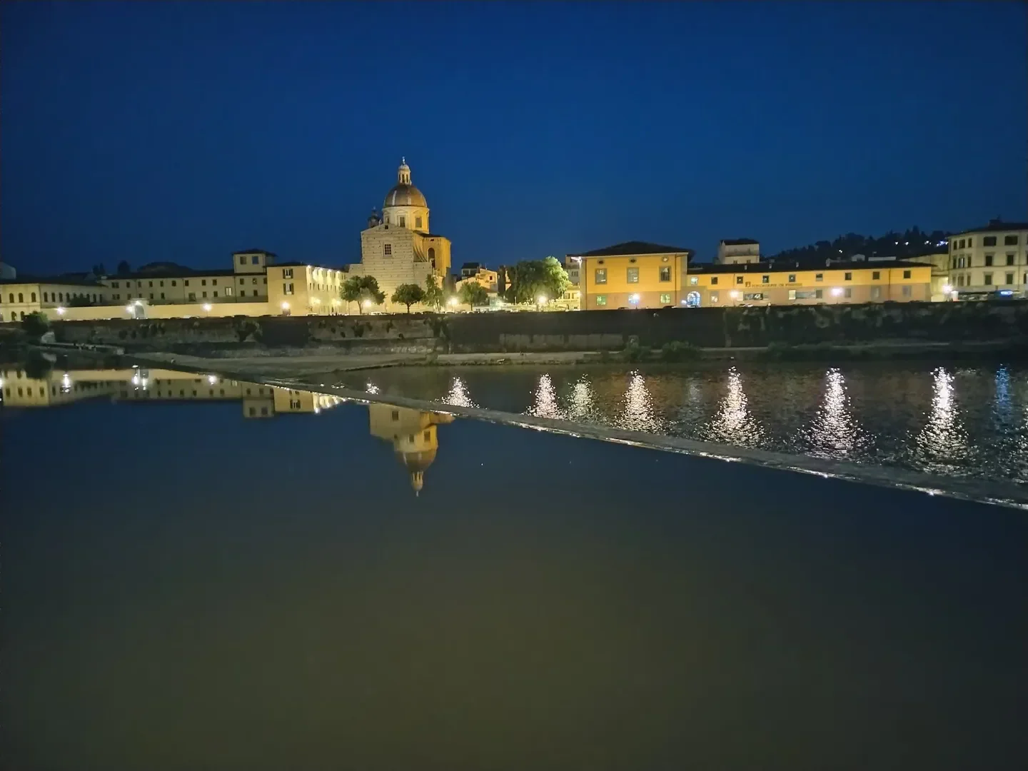 Night view in Florence, near Iridium Spa at The St. Regis Florence, with buildings and reflections