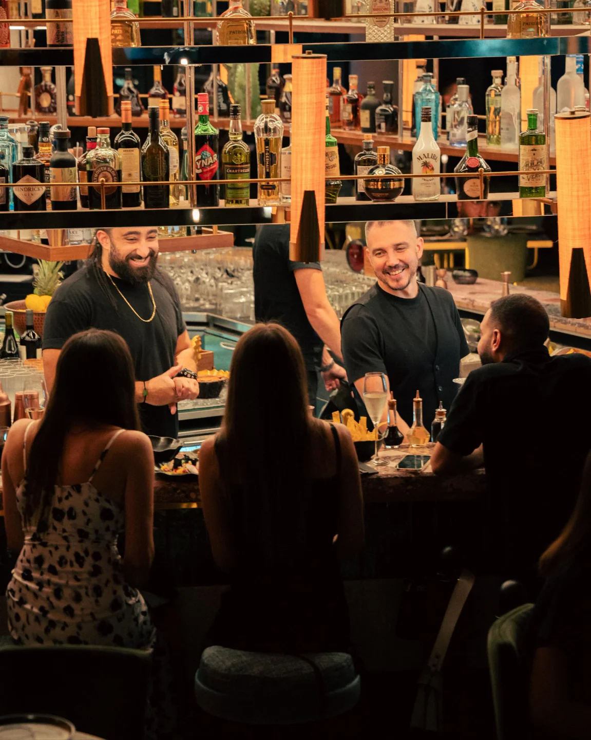 Bartenders serving drinks at the illuminated bar in Iris Harbour restaurant, located in the city.