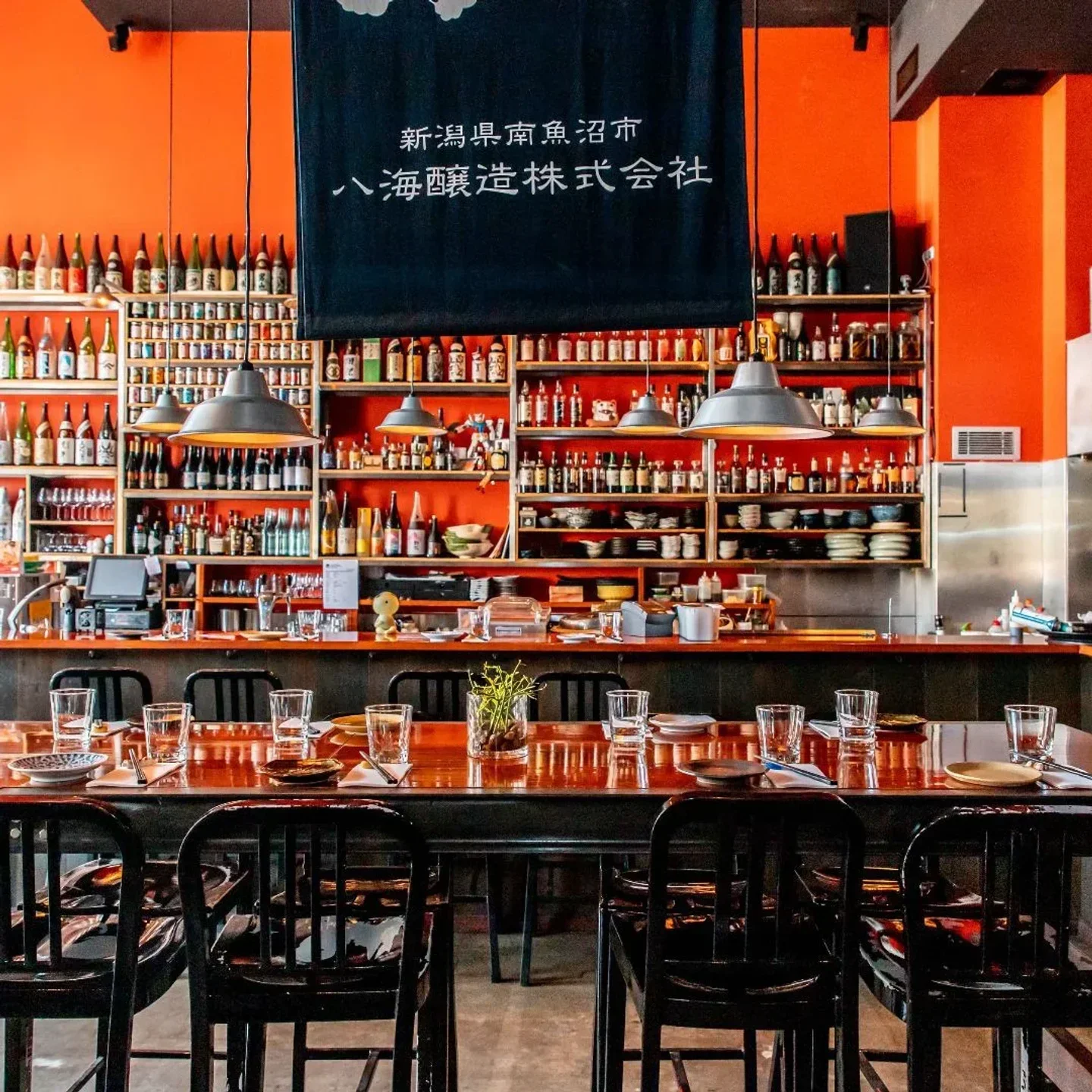 Interior of Izakaya Fujiyama in Sydney with a fully set table and bar in the background.