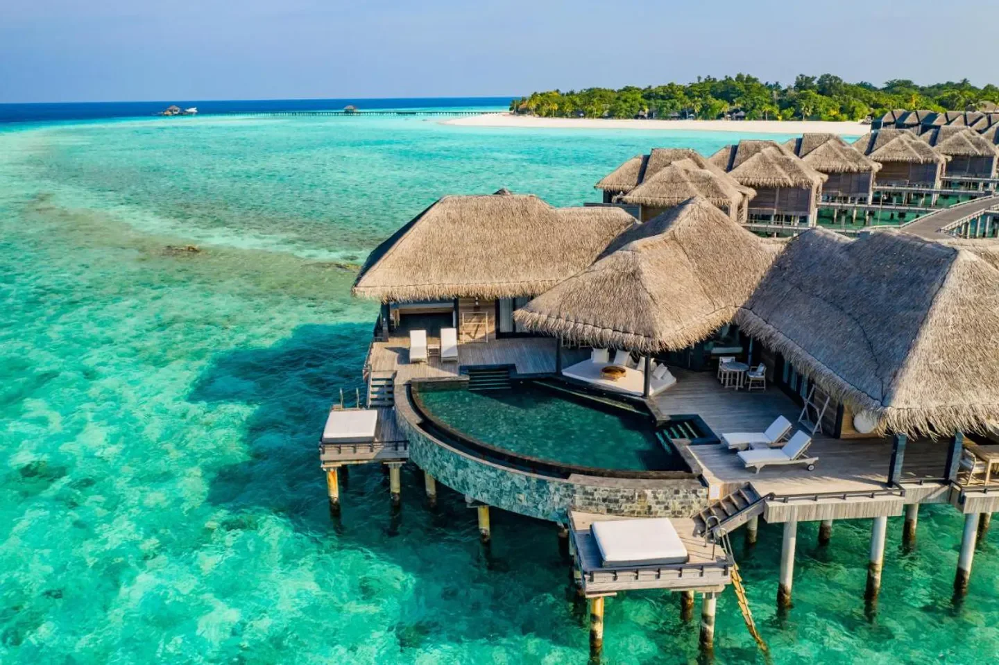 Overwater bungalows at JA Manafaru in the Maldives with turquoise waters and a pool