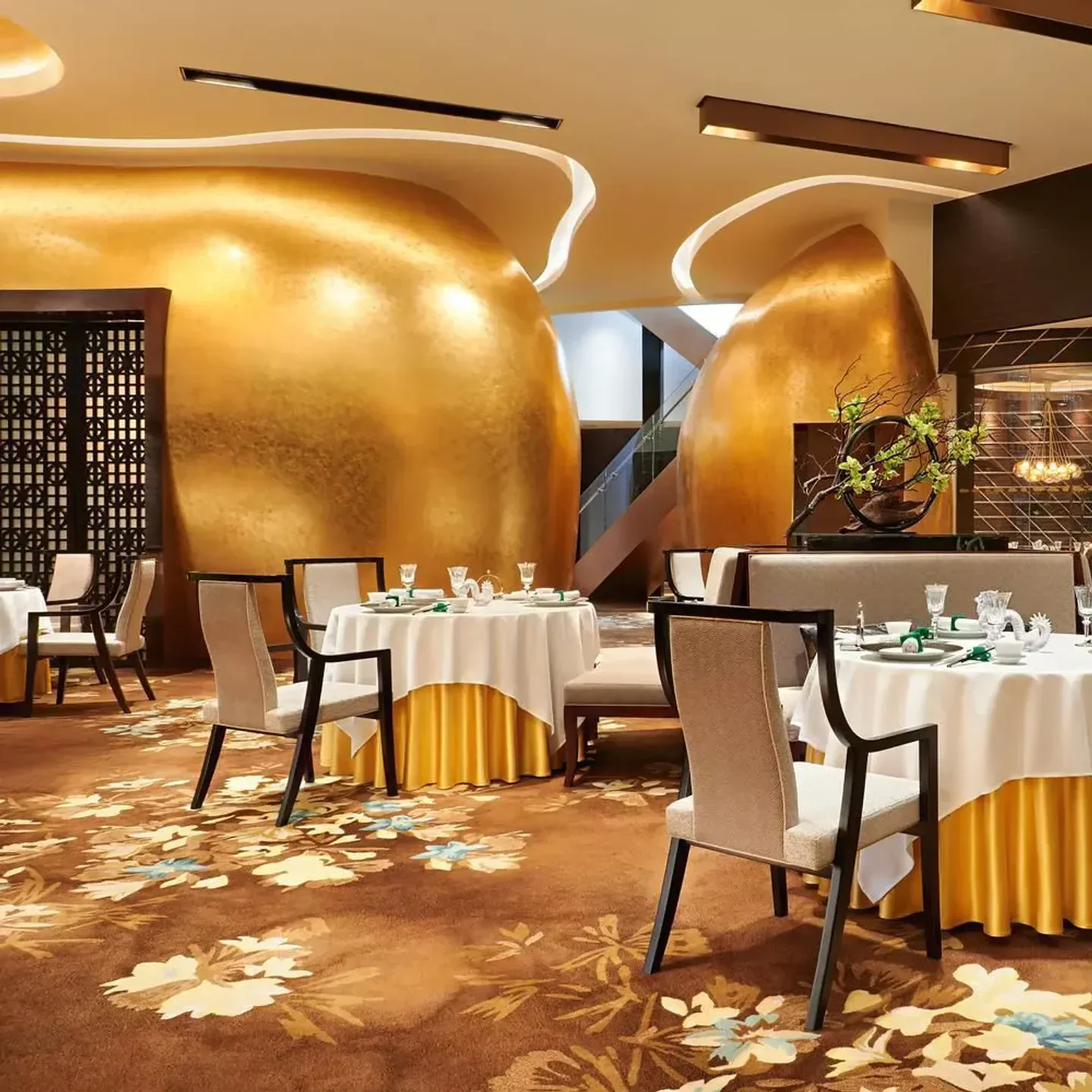 Jade Dragon in Macau: Elegant dining room with golden decor and floral carpet