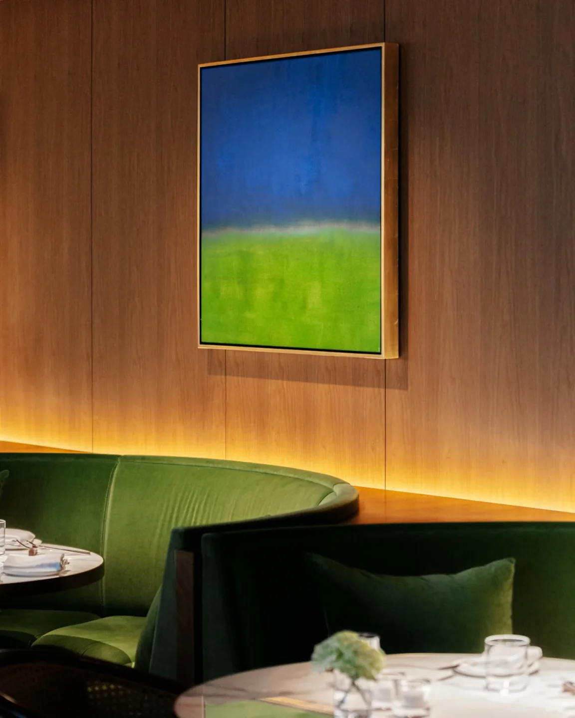 Luxurious green velvet booths and abstract art adorn the interior of Jade Room in Tokyo.