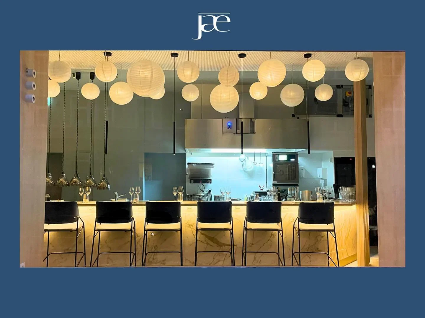 Interior of Jae restaurant in Düsseldorf, featuring stylish bar and paper lantern lights.
