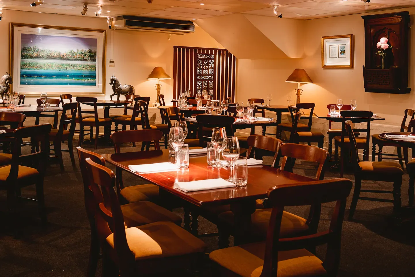 Cozy dining room at Jasmin restaurant in Adelaide, featuring wooden tables and chairs.