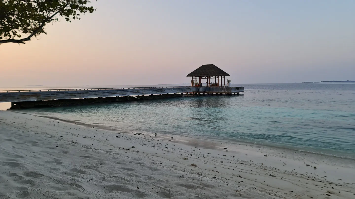 Seaside spa pier at Javvu Spa in The Bahamas at sunset, tranquil scene.