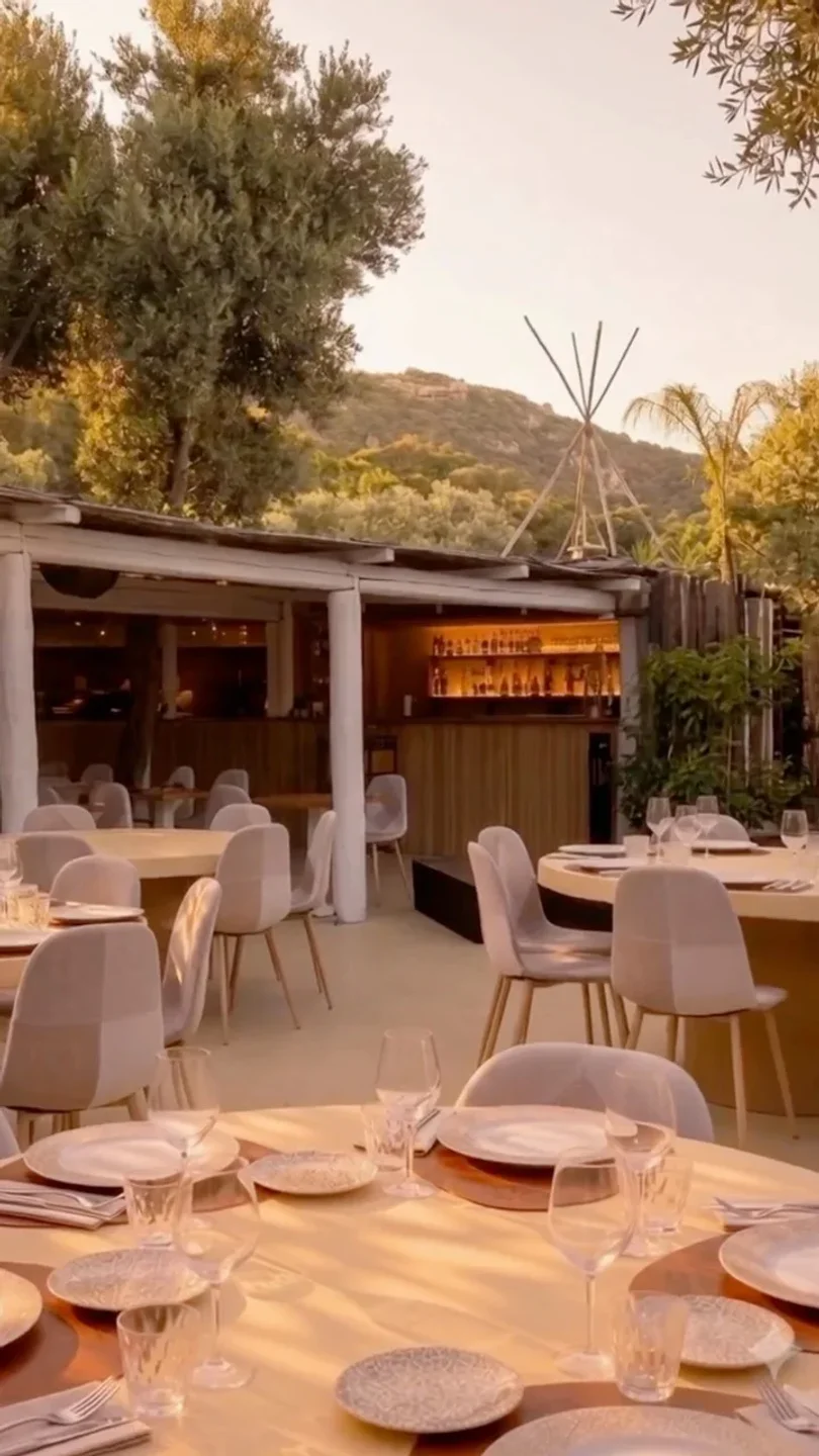 Jerò restaurant in Porto Cervo features a chic outdoor seating area with elegant tables and a well-stocked bar.