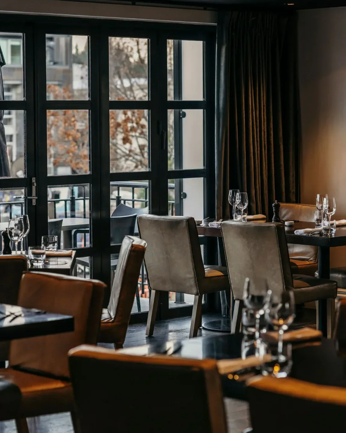 Elegant dining interior at Jervois Steak House in Queenstown, with large windows