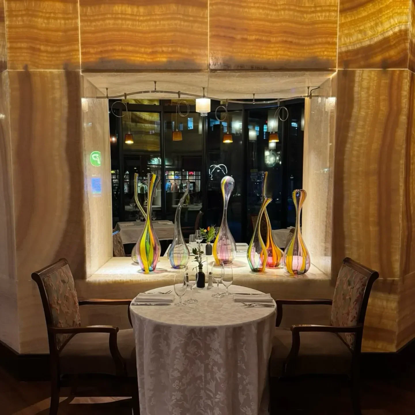 Elegant dining table at Jill's Restaurant in Boulder, showcasing colorful glass art and ambiance.