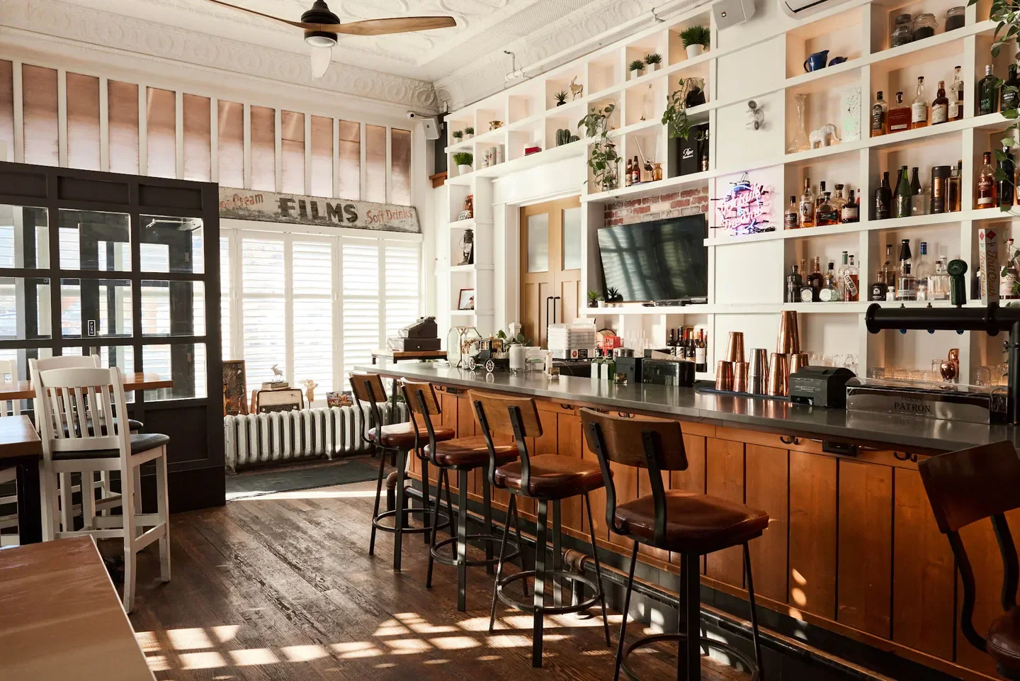 Interior of JinBar restaurant in Calgary with bar stools and a fully stocked bar.