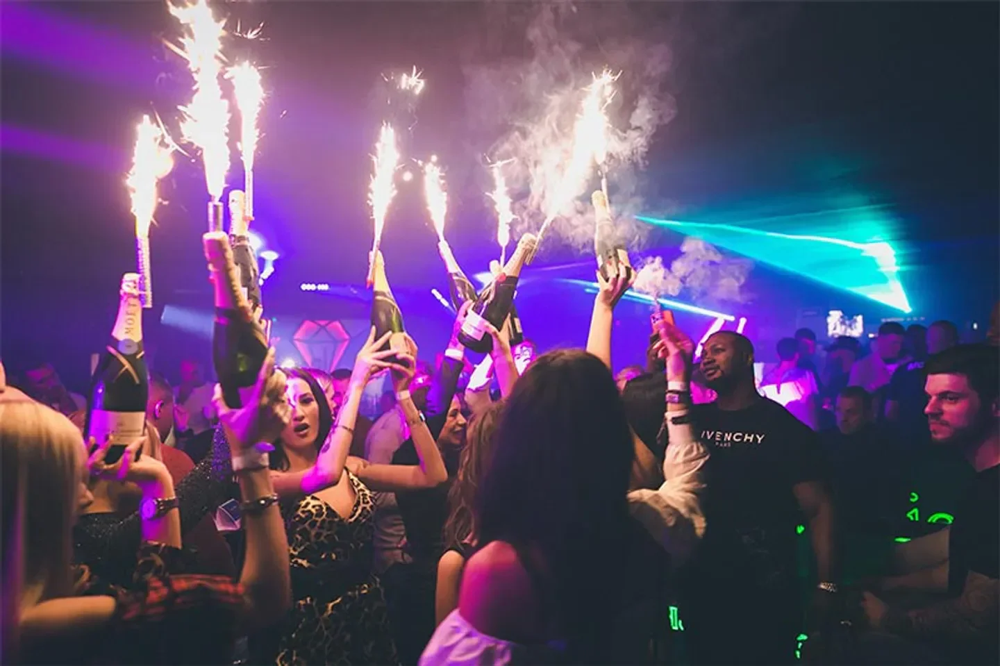 Celebration at Jolie Club in Rome, with champagne and sparklers at a lively nightclub.