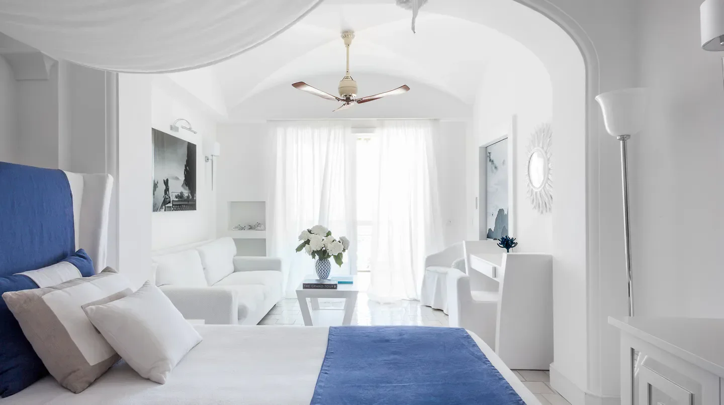 Elegant white bedroom at Jumeirah Capri Palace hotel in Capri, featuring stylish decor.