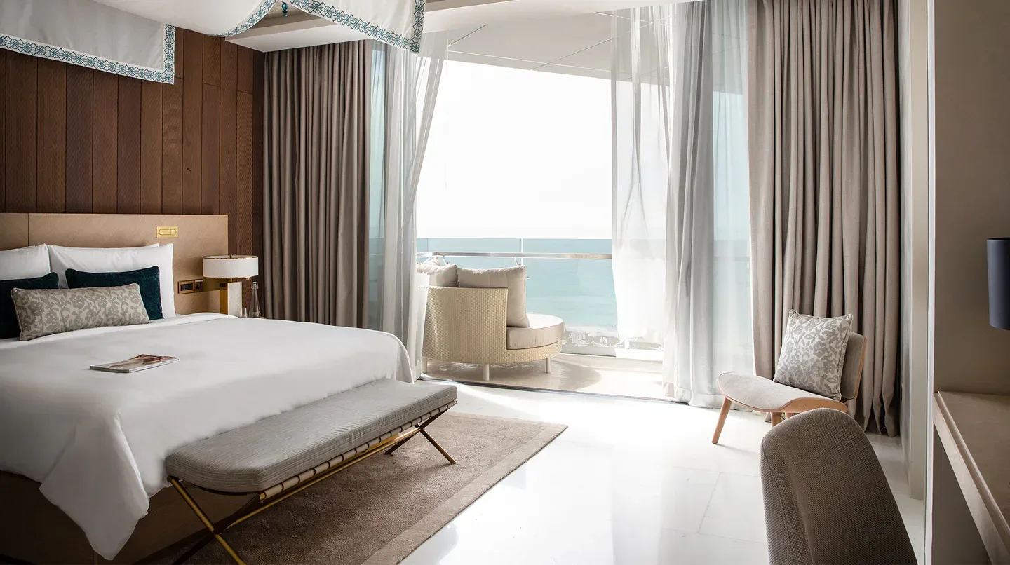 Luxury bedroom at Jumeirah Saadiyat Island in Abu Dhabi, with ocean view and balcony.