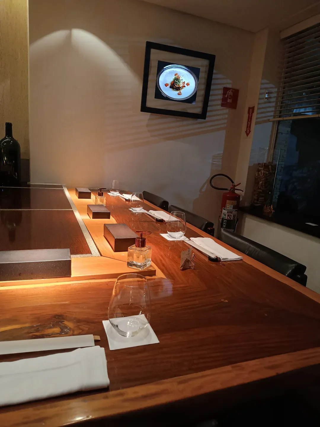 Dining table at Jun Sakamoto restaurant in Sao Paulo, with food art on the wall.