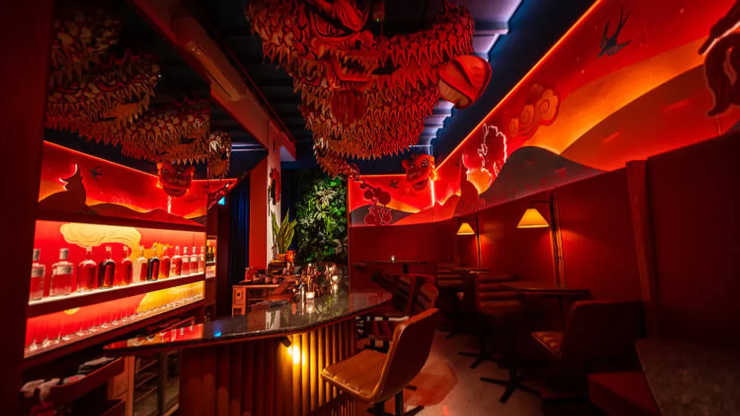 Interior of Junior The Pocket Bar in Singapore, with dragon decor and ambient lighting.