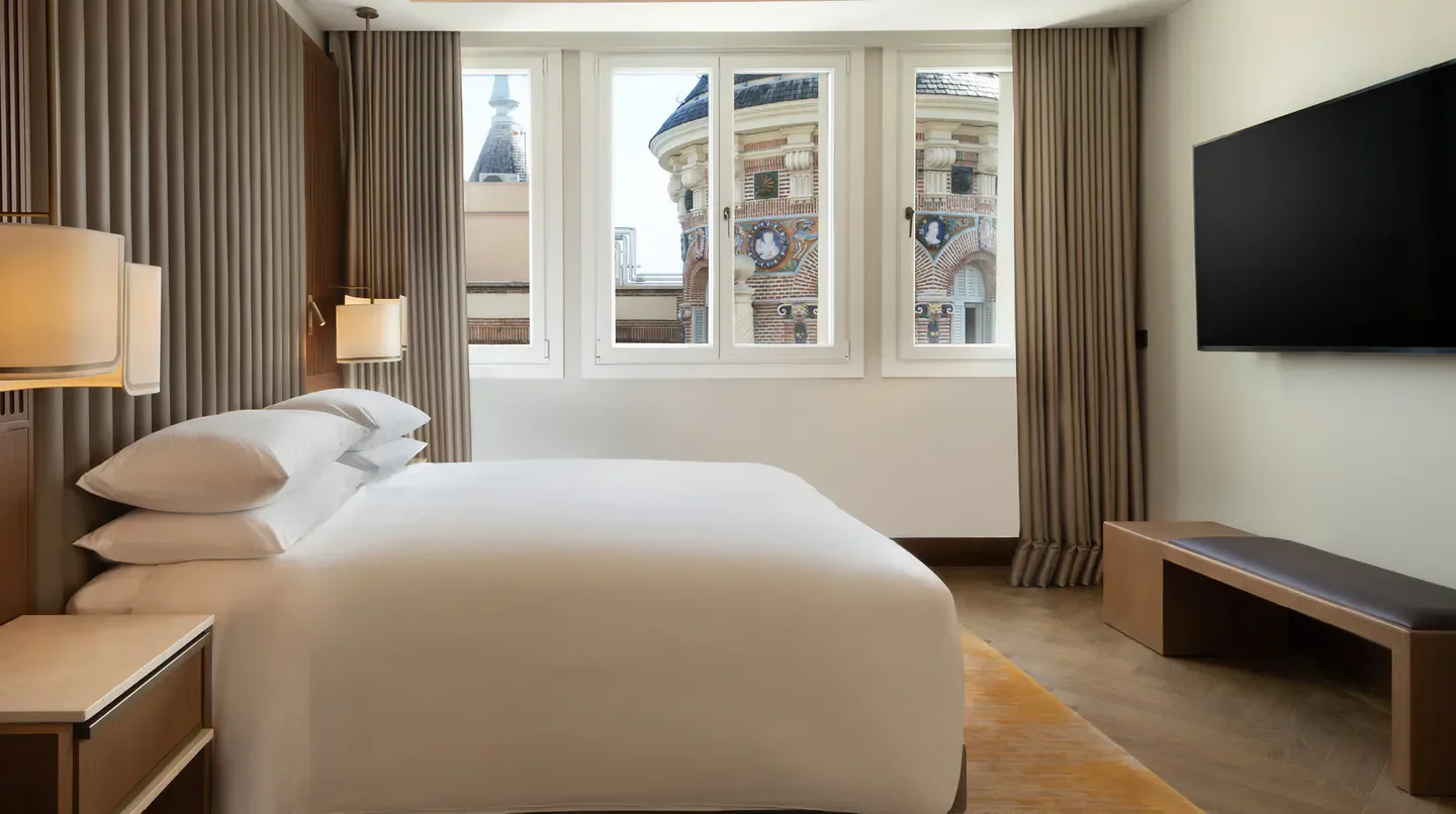 Luxury bedroom at JW Marriott Hotel Madrid, featuring a view of the beautiful Madrid architecture.