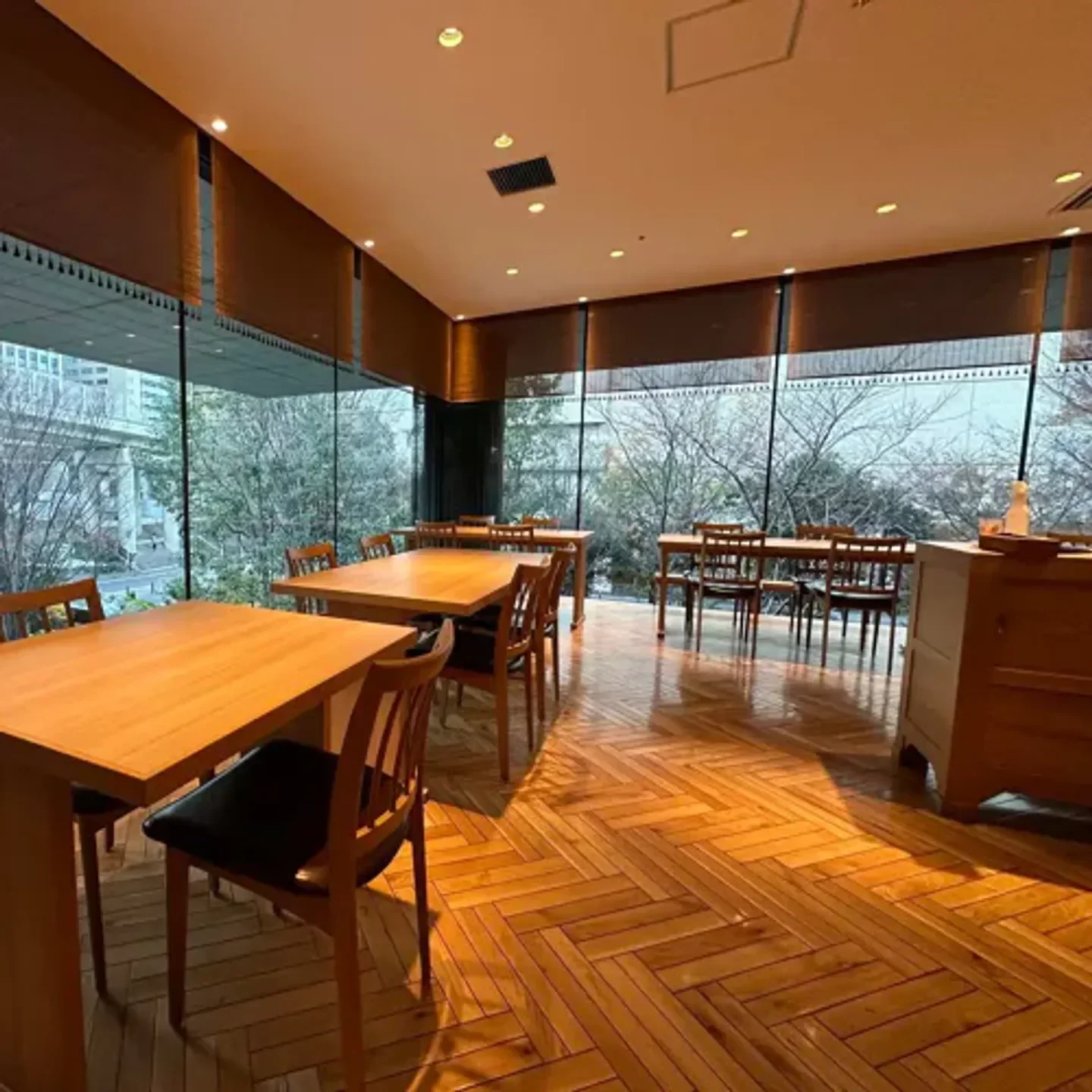 Interior dining space at Kaishoku Shimizu restaurant in Osaka, with wooden tables and floors.