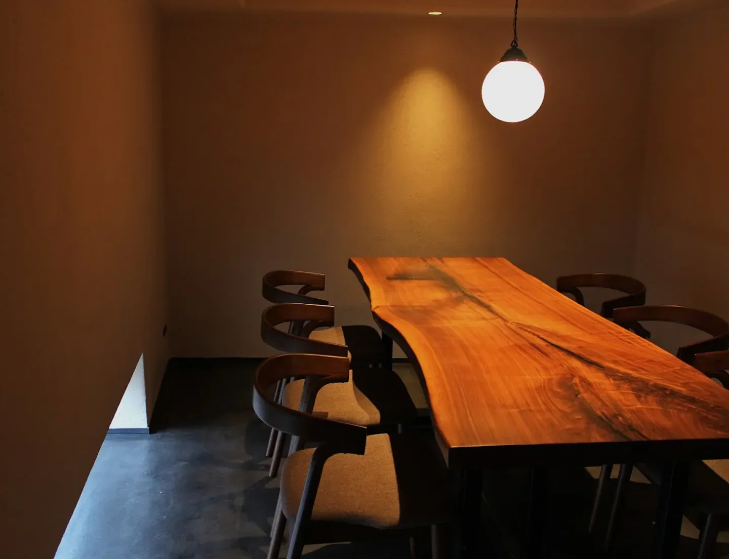 Interior dining space at Kamigatachuka SHINTANI restaurant in Osaka, featuring wooden table and chairs.
