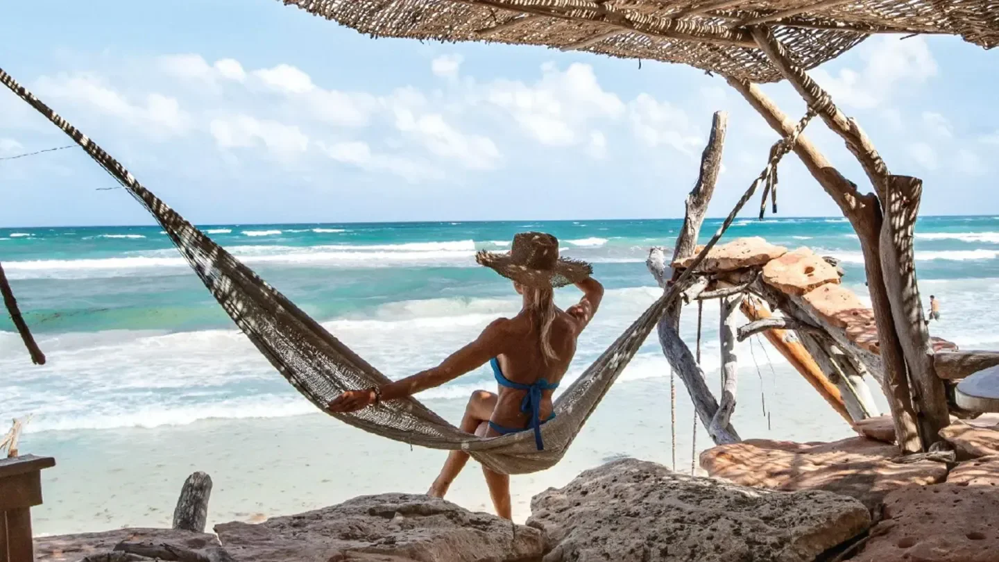 Relaxing in a hammock at Kanan Beach Club in Tulum, enjoying the ocean view.