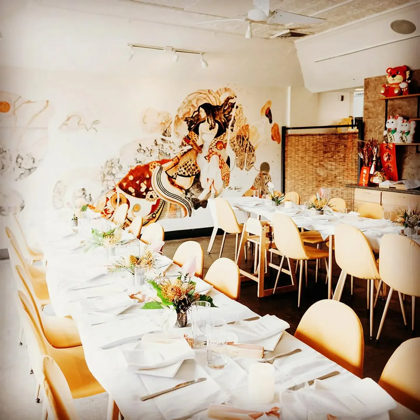 Interior of Kapa Hale restaurant in Honolulu, featuring decorated tables and wall art.