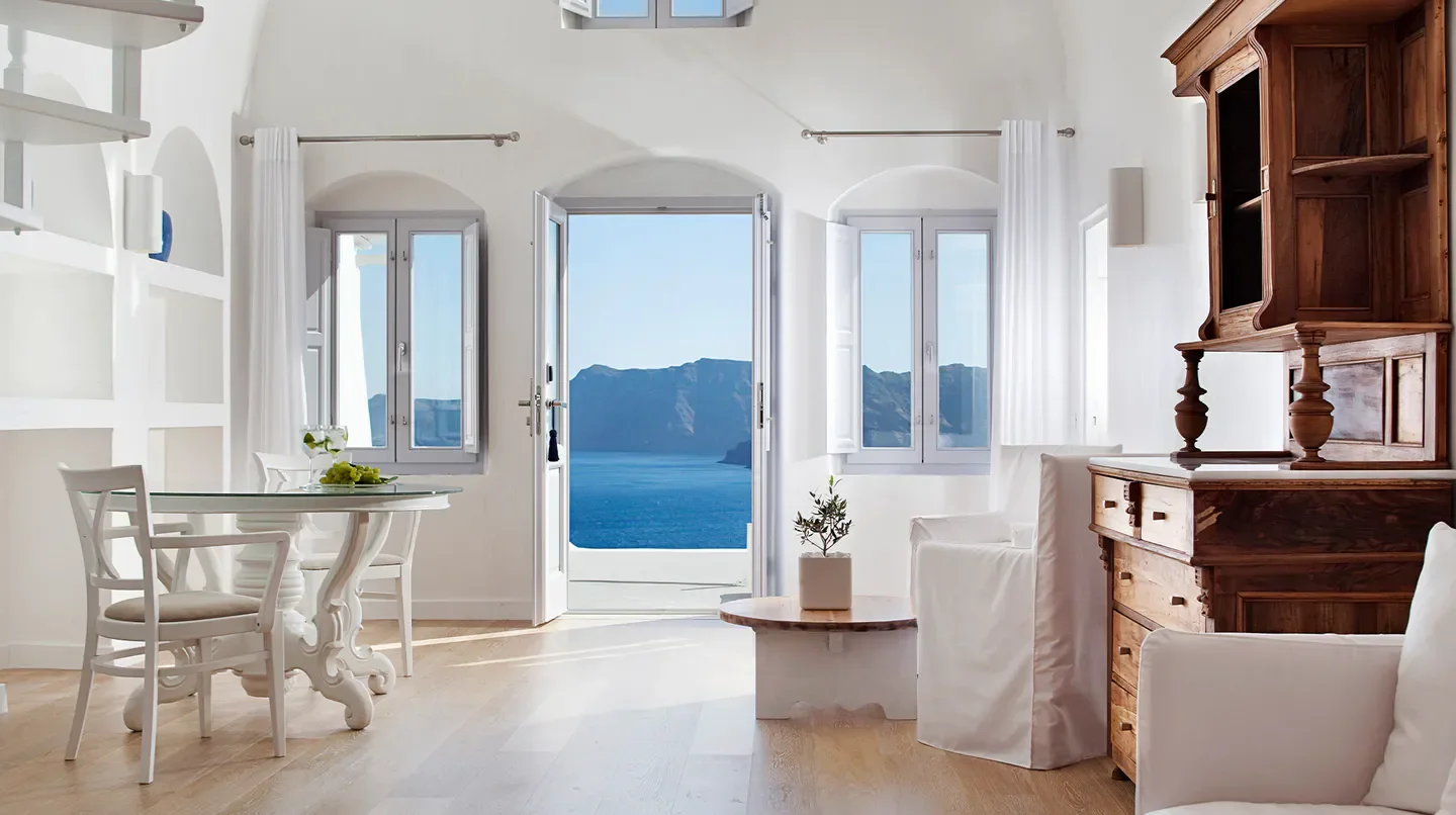 Interior of Katikies Santorini hotel room with open doors overlooking the Santorini sea