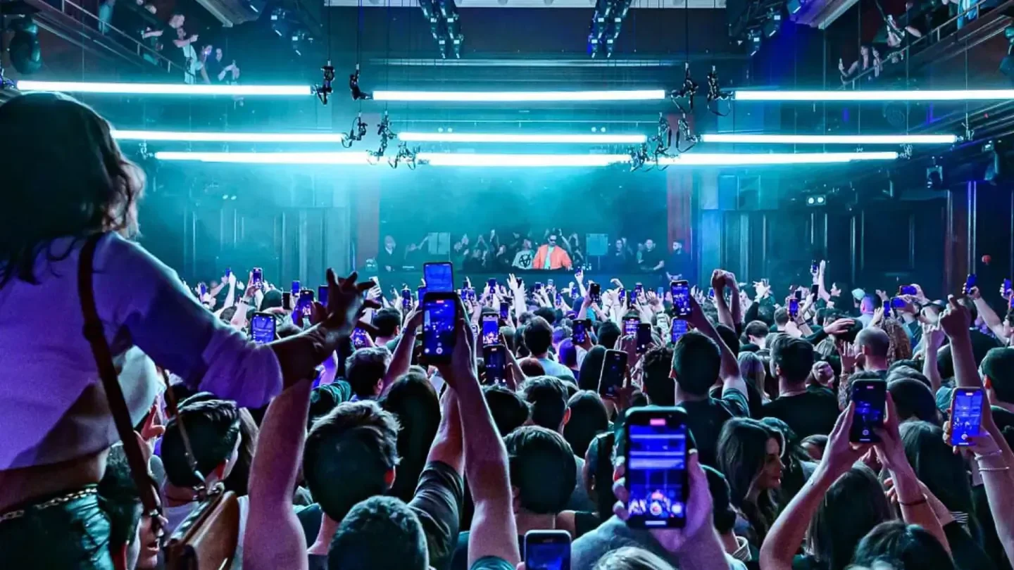 Energetic crowd at Kaufleuten nightclub in Zurich, recording the DJ on their phones