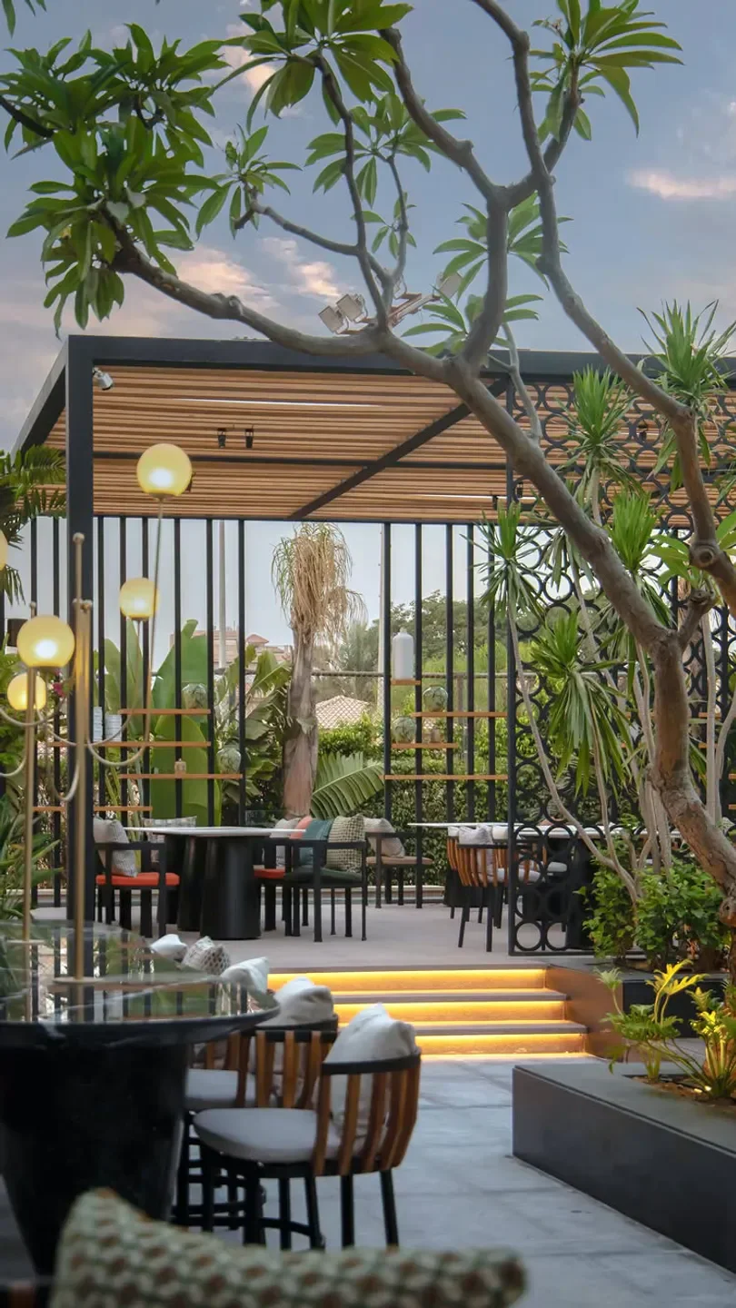 Outdoor dining area at Kazoku in Cairo, featuring stylish decor and lush greenery.