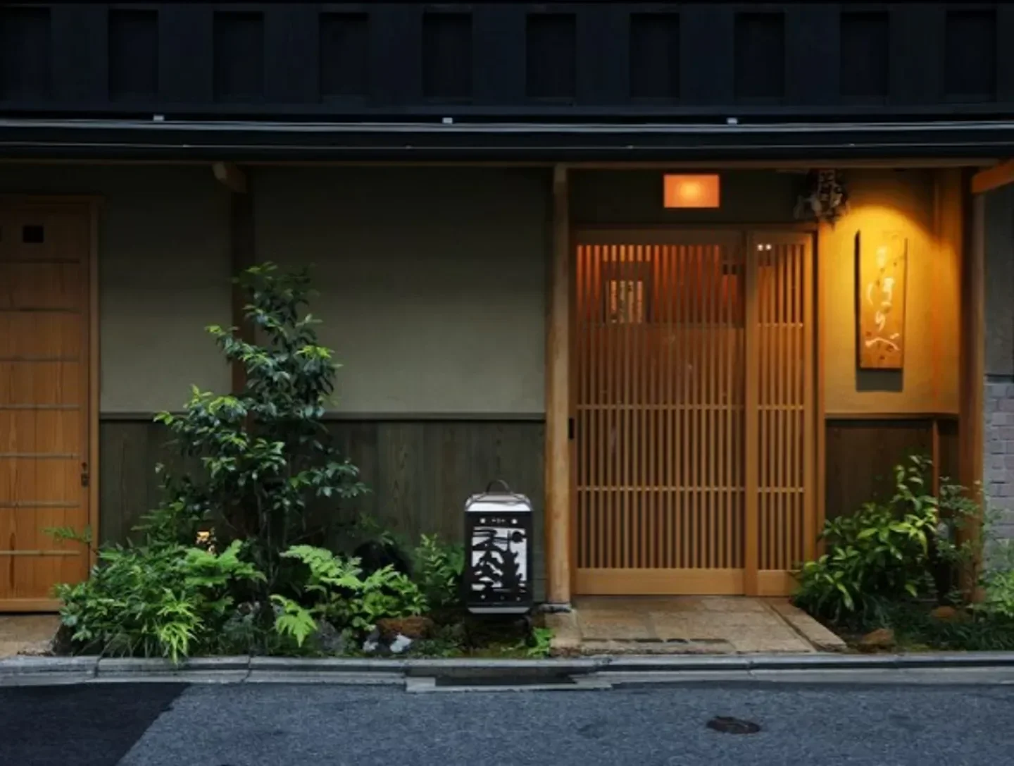 Entrance of Kentan Horibe restaurant in Kyoto, with traditional wooden doors and plants.