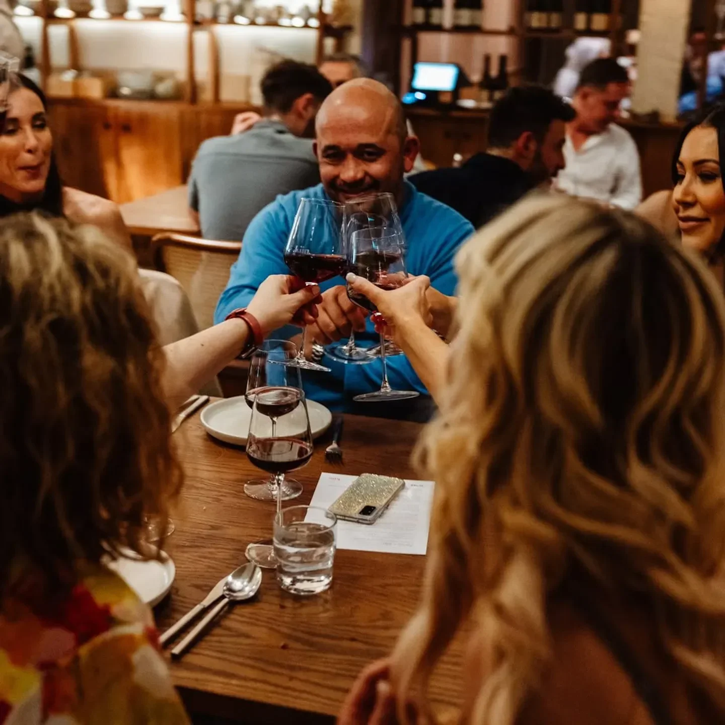 Cheers at Kiin Adelaide restaurant: friends toasting with glasses of red wine