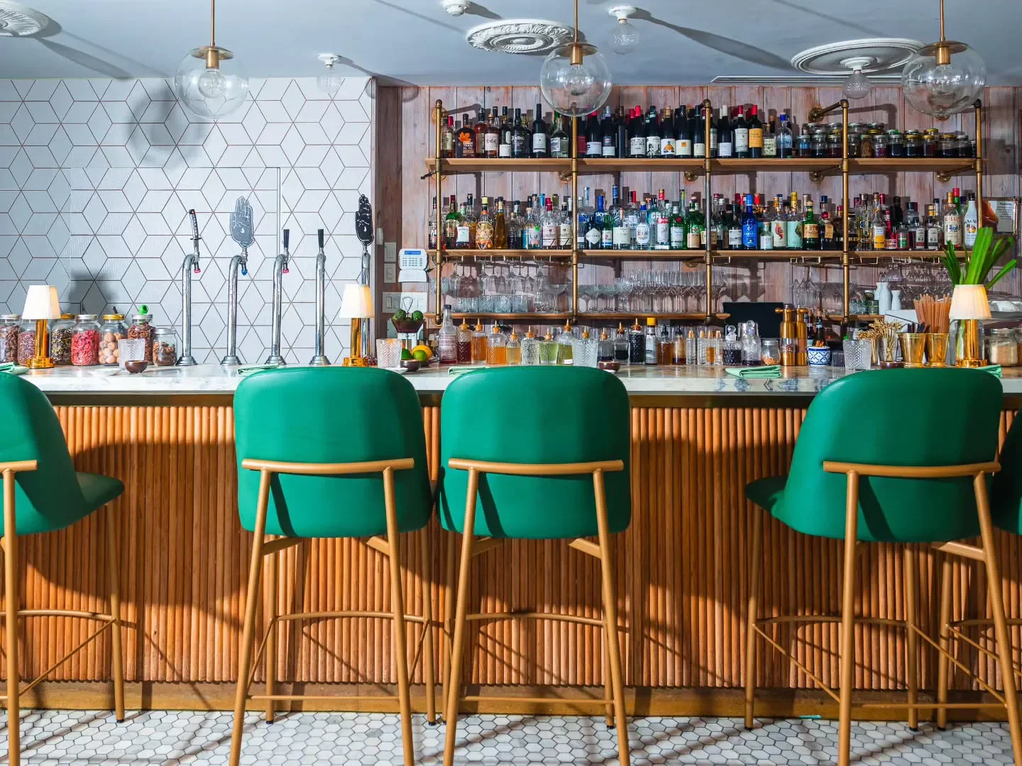 Interior of KIIN restaurant in Toronto, with green bar stools and stylish design.