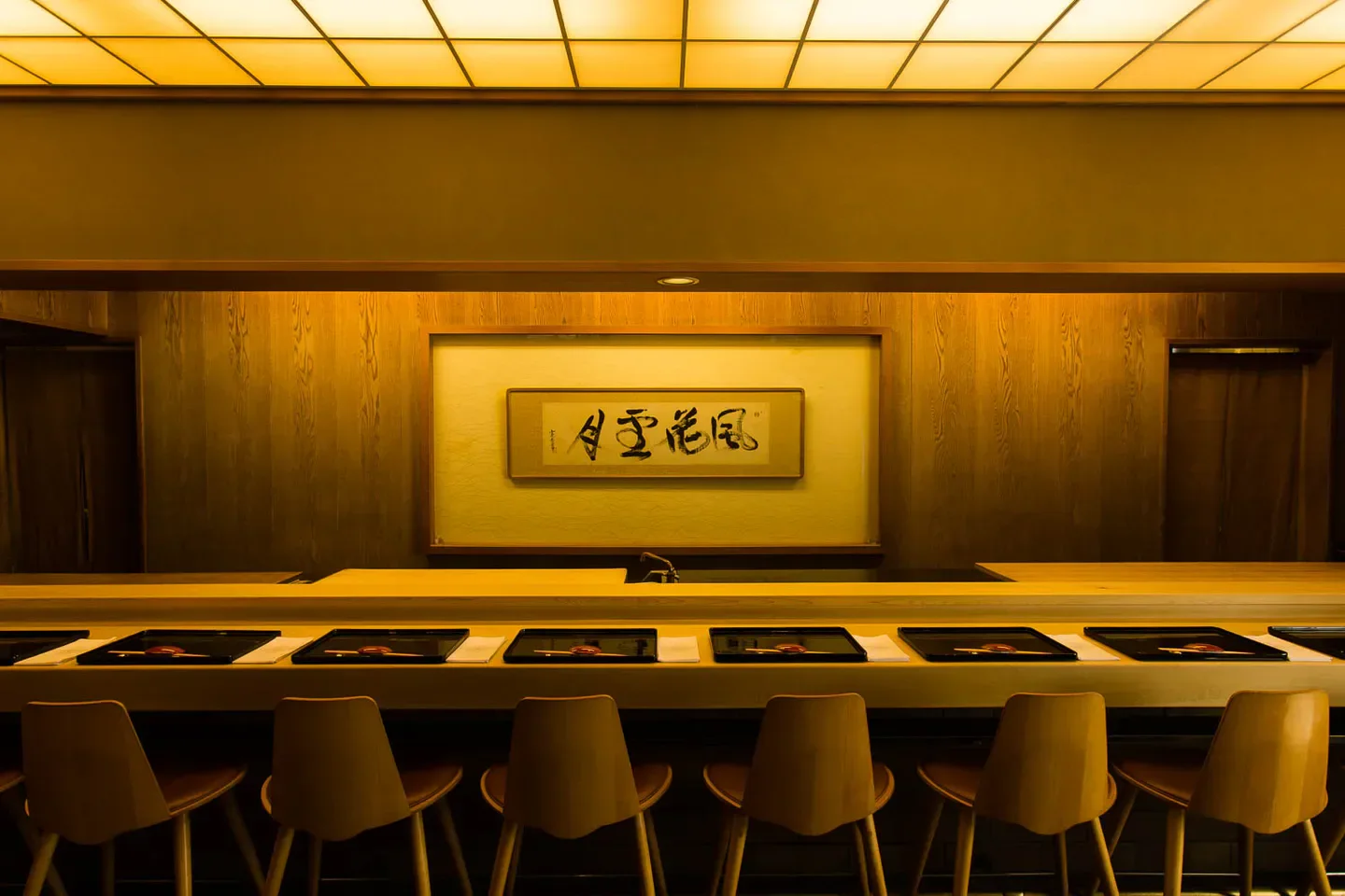 Elegant dining space at Kikunoi Roan in Kyoto, featuring wood decor and calligraphy.
